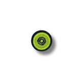 Fotografía de un parche bordado con diseño de kiwi en tonos verde vibrante y borde negro, sobre fondo blanco con sombra suave.