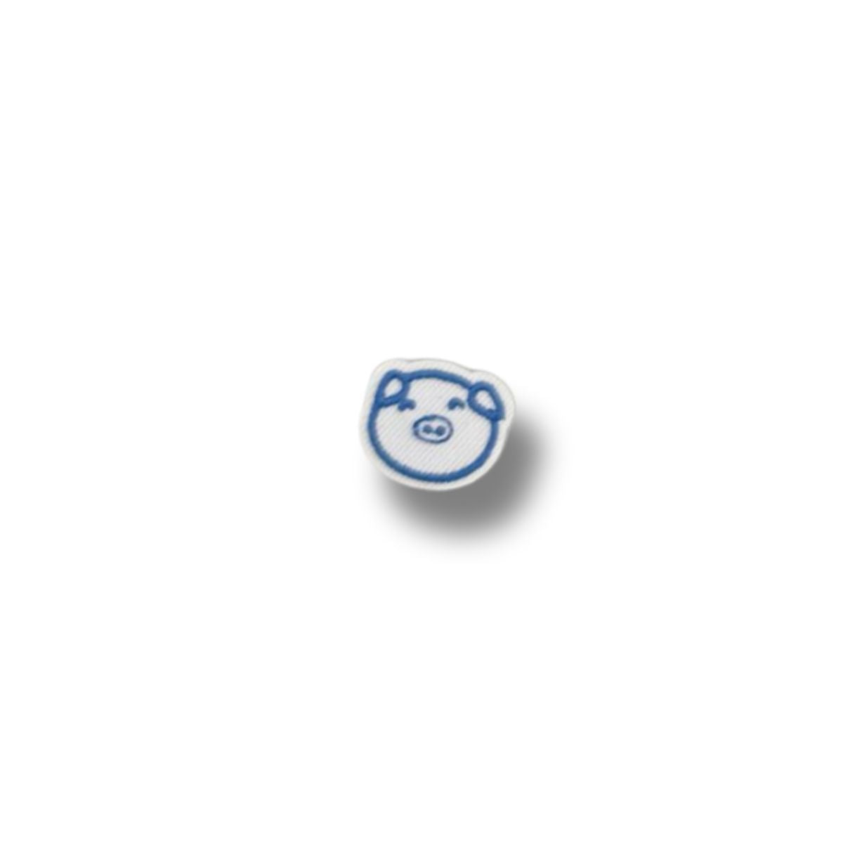 Parche bordado de cara de cerdito azul con contorno blanco y expresión amigable.