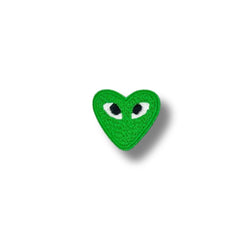 Corazón verde con ojos bordados en blanco y negro.
