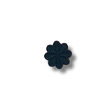 Flor bordada negra de ocho pétalos con acabado mate.