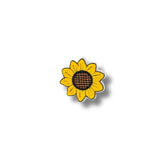 Primer plano del parche bordado de girasol, con pétalos amarillos intensos y centro marrón sobre fondo blanco.