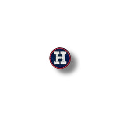 Parche circular con la letra "H" bordada en blanco sobre fondo azul marino, borde rojo fino.