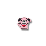 Primer plano de parche bordado de perrito rosa saludando, con contornos negros y detalles en rojo y blanco, fondo claro.